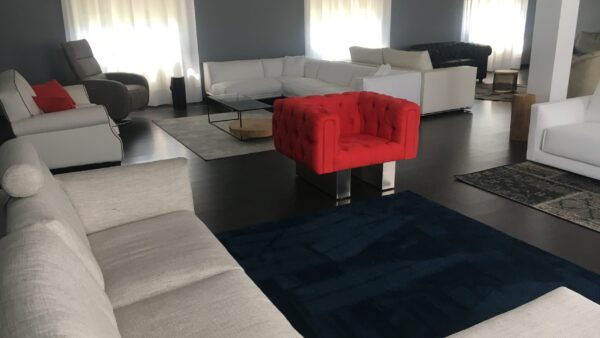 Poltrona Chester su disegno con rivestimento rosso e struttura raffinata, fornita da Tino Mariani a Lissone in provincia di Monza e Brianza.