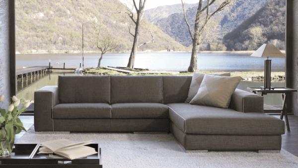 Una casa con vista sul lago e in salotto si vede Blow, il divano angolare con chaise longue realizzato su misura da Tino Mariani.